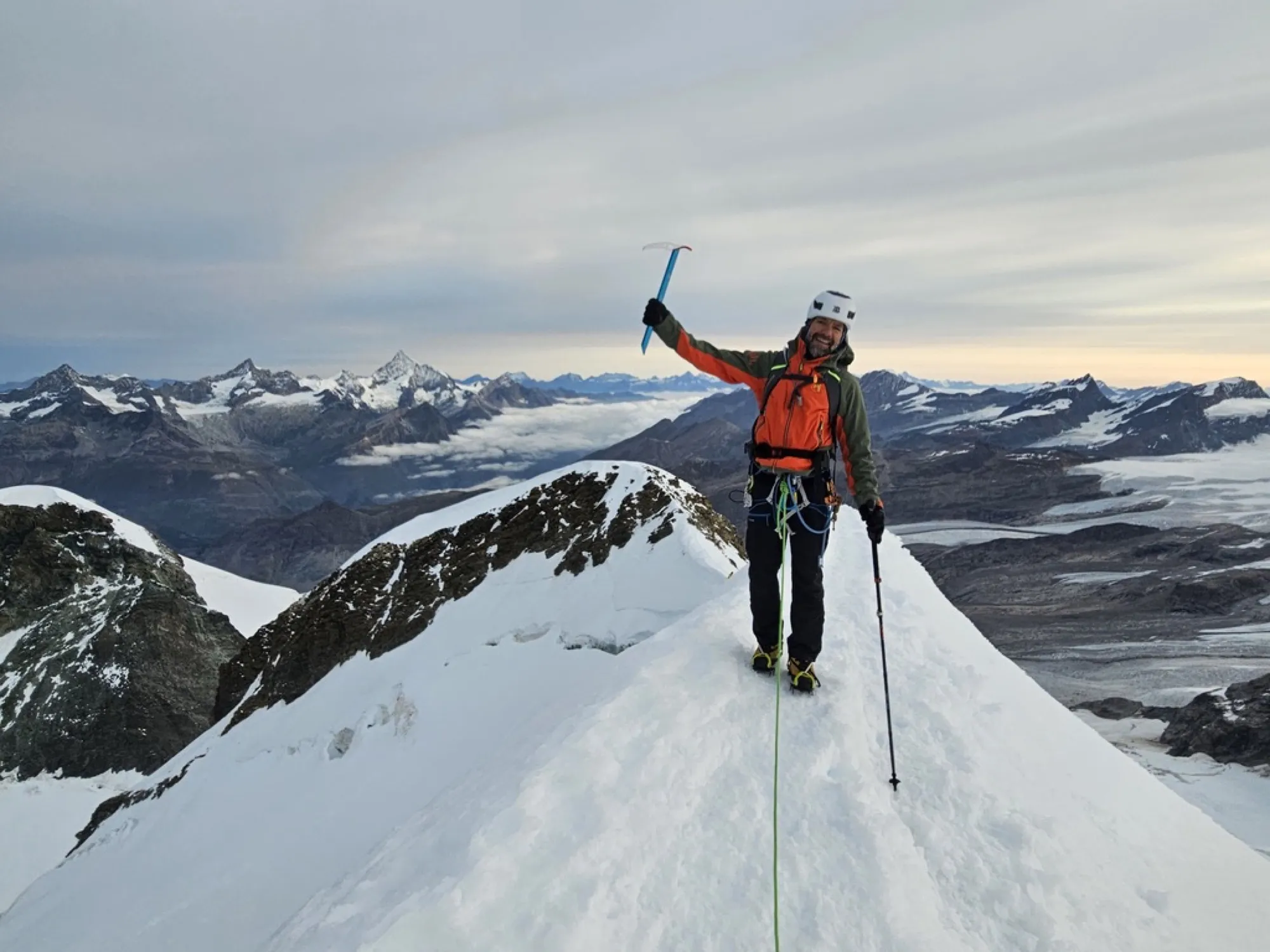 Mehdi on the summit of Castor, ice axe raised